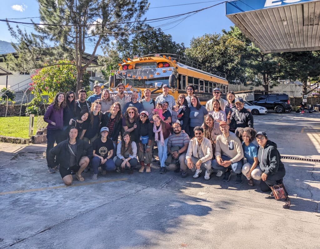 group of people in front of a chicken bus