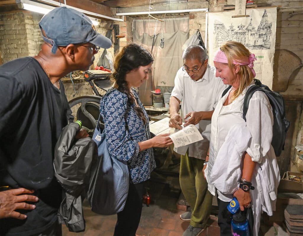 people in small workshop looking at notebook