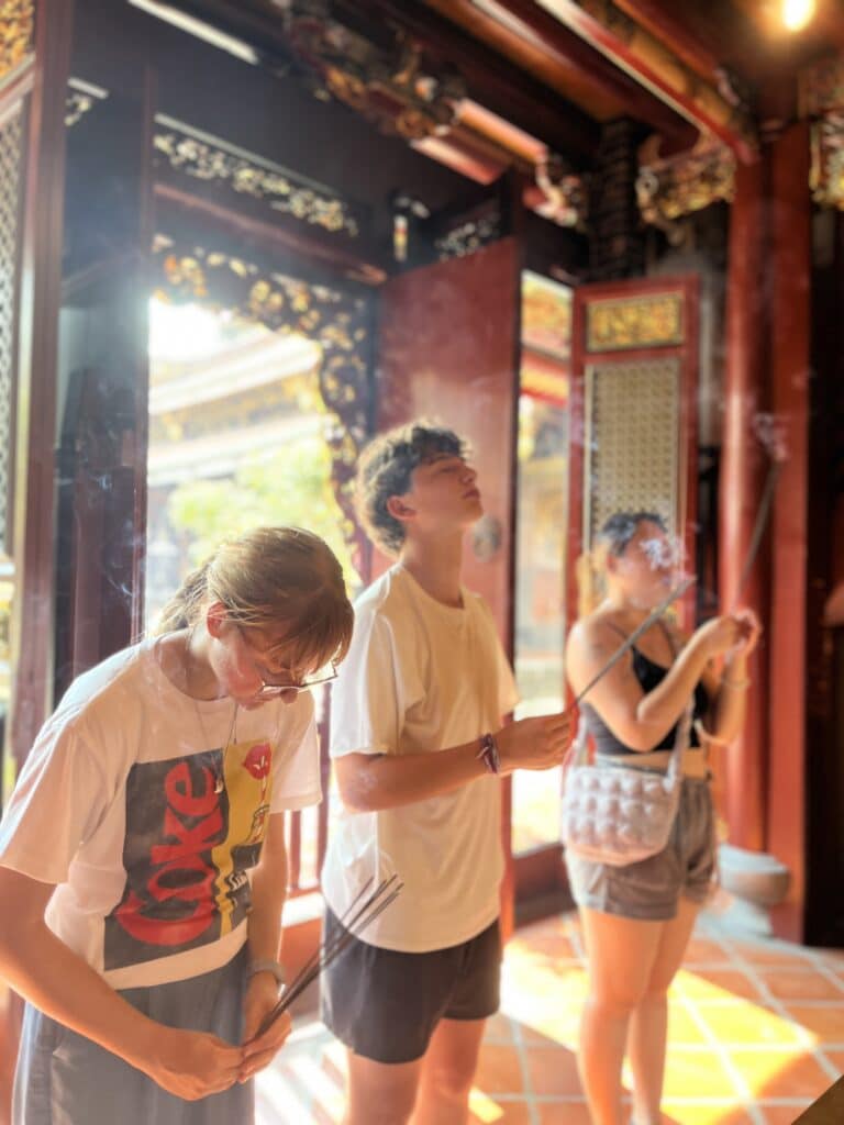 people standing in temple burning incense