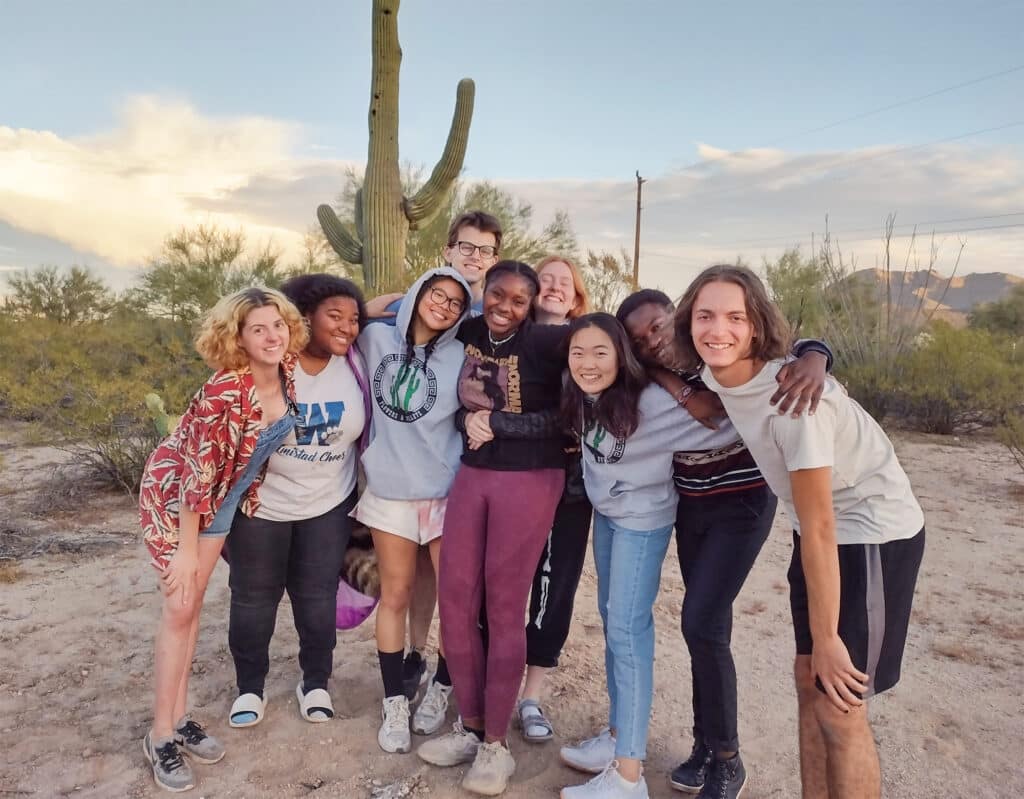 small group in front of cactus smiling for camera